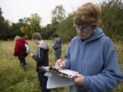 Volunteer Jane Skelly writes down data at the Eco-Blitz at Vancouver Lake. Volunteers recording wildlife in and around the lake.