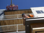 Construction worker George Somarakis installs drip metal at Isabella Court on Monday in central Vancouver. The 49-unit subsidized housing complex for seniors is set to open in November.