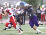 Heritage defensive lineman White Sosene (55) chases West Valley quarterback Brandon Battle (8) at McKenzie Stadium.