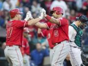 Los Angeles Angels' Albert Pujols, right, is congratulated by teammate Mike Trout after hitting a two-run home run off of Seattle Mariners relief pitcher Pat Venditte that scored Trout during the second inning of a baseball game, Saturday, Sept. 3, 2016, in Seattle. The home run was the second by Pujols in as many innings.