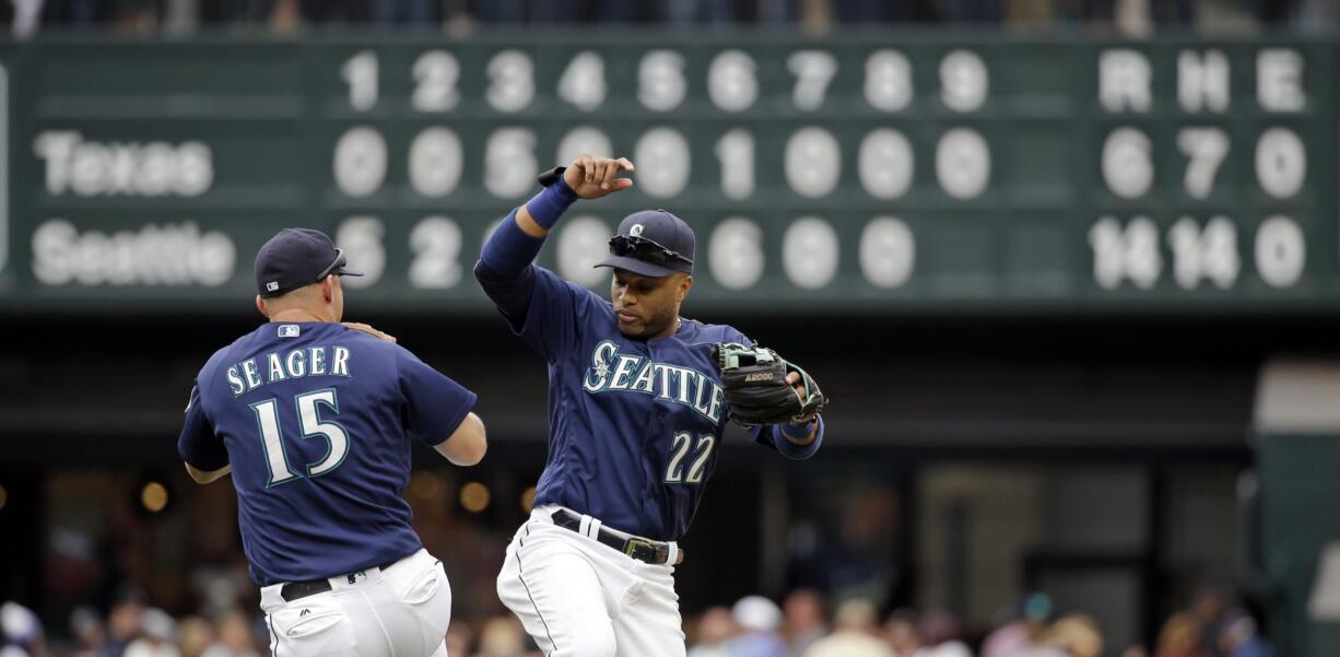 Seattle Mariners Kyle Seager (15) and Robinson Cano share congratulations after the Mariners defeated the Texas Rangers 14-6 in a baseball game Monday, Sept. 5, 2016, in Seattle.