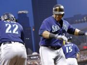 Seattle Mariners' Nelson Cruz, right, and Robinson Cano celebrate Cruz's two-run home run off Minnesota Twins pitcher Tyler Duffey during the fourth inning of a baseball game Saturday, Sept. 24, 2016, in Minneapolis.