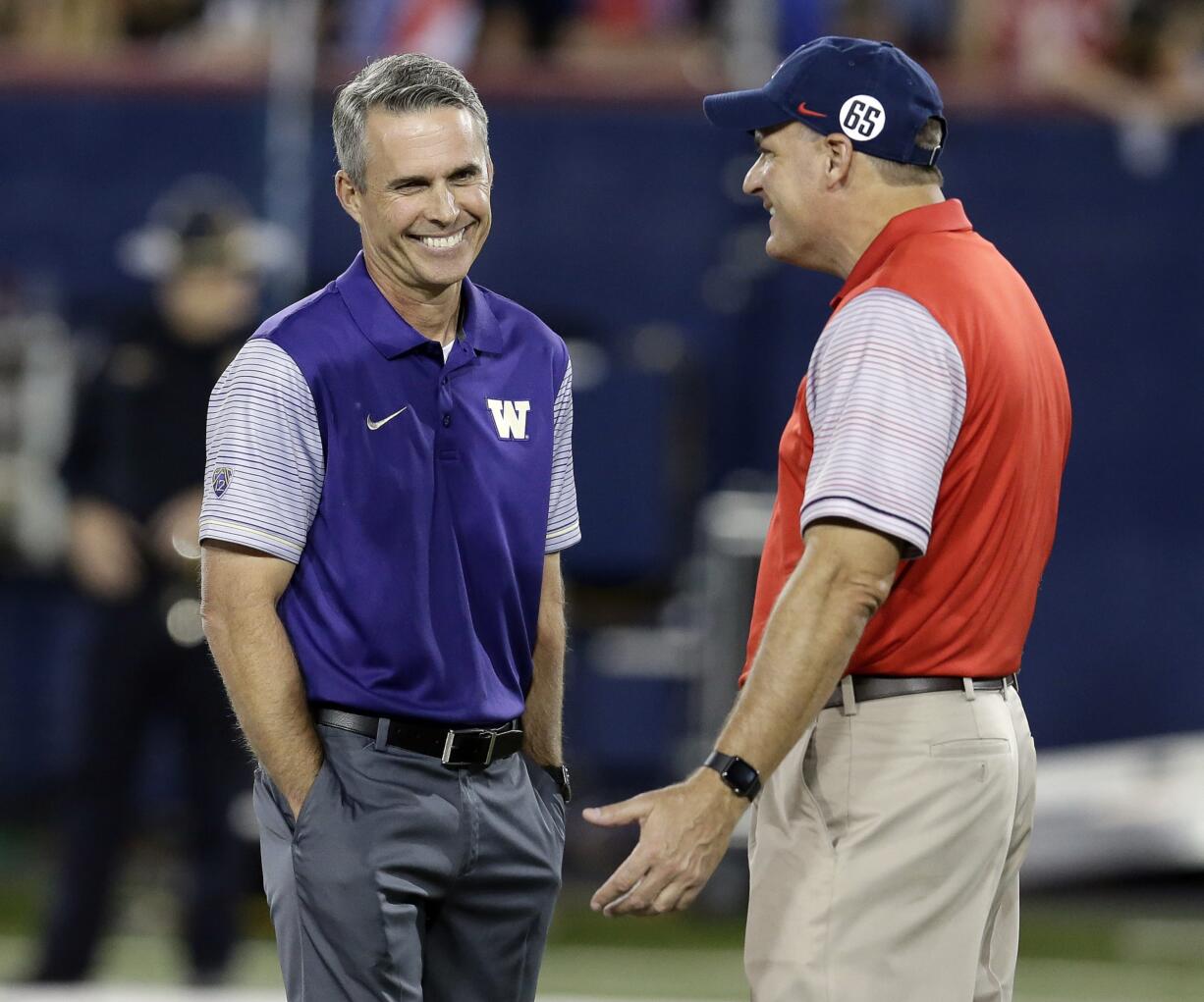 Washington coach Chris Petersen, left, talks to Arizona coach Rich Rodriguez before an NCAA college football game, Saturday, Sept. 24, 2016, in Tucson, Ariz.