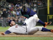 Houston Astros&#039; Tyler White slides safely across home as Seattle Mariners catcher Mike Zunino follows through on a tag during the sixth inning. White and Teoscar Hernandez scored on a single by Yulieski Gurriel on the play.