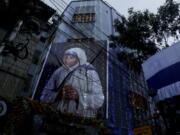 Mother House of the Missionaries of Charity group founded by Mother Teresa is illuminated with a huge portrait of her displayed in Kolkata, India, Sunday, Sept. 4, 2016.