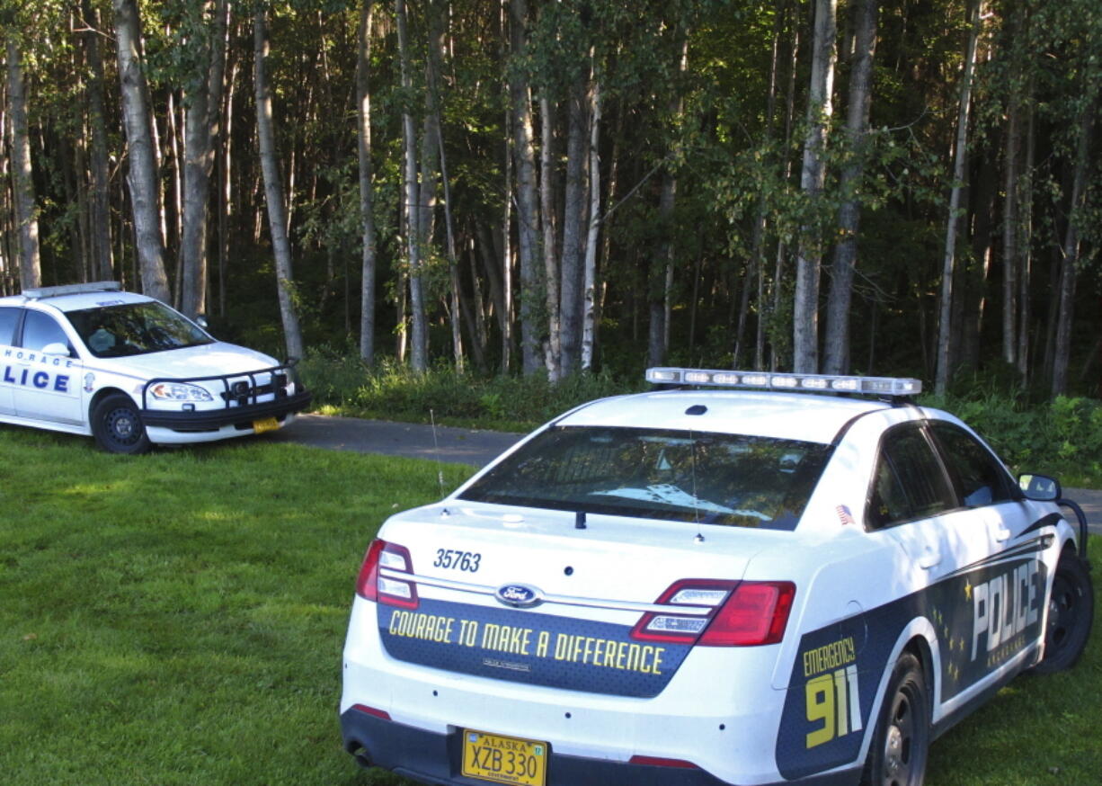 Police cars sit Wednesday at Valley of the Moon Park in Anchorage, Alaska, where two people were found dead last weekenda. The double homicide is among nine unsolved cases this year in which people have been found dead in Anchorage parks, trails and on isolated streets.