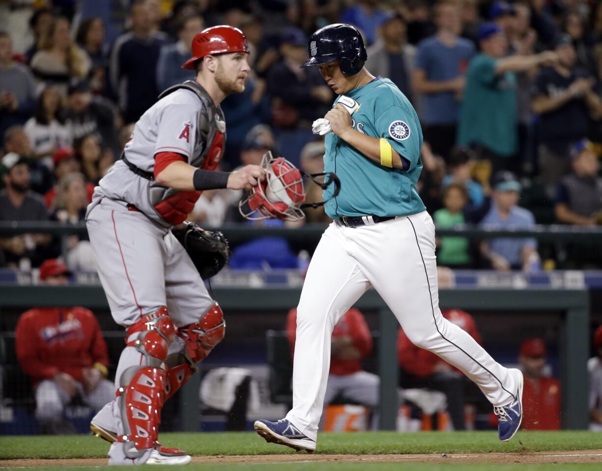 Seattle Mariners' Dae-Ho Lee scores as Los Angeles Angels catcher Jett Bandy waits for the ball Friday night.