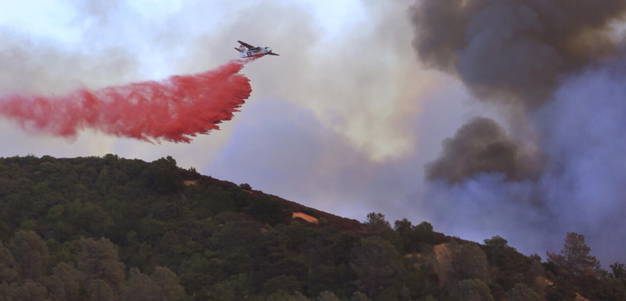 A Cal Fire air tanker makes a drop on the head of the Sawmill fire in the Geysers near Cloverdale Calif. A wildfire that erupted amid hot, dry conditions and gusty winds in Sonoma County north of San Francisco was burning close to a massive geothermal power producing facility forcing the evacuation of one of its 14 plants, officials said Monday, Sept. 26, 2016.