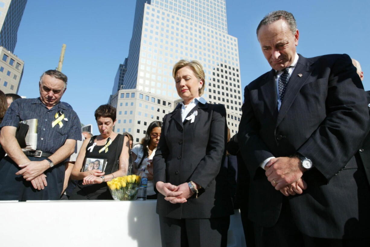 Then-Sen. Hillary Clinton, D-N.Y., center, and Sen. Charles Schumer, D-N.Y., right, bow their heads during a moment of silence as they join mourners gathering to remember those lost during the terrorist attacks on the World Trade Center at ground zero in New York on Sept. 11, 2003.