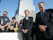 Then-Sen. Hillary Clinton, D-N.Y., center, and Sen. Charles Schumer, D-N.Y., right, bow their heads during a moment of silence as they join mourners gathering to remember those lost during the terrorist attacks on the World Trade Center at ground zero in New York on Sept. 11, 2003.