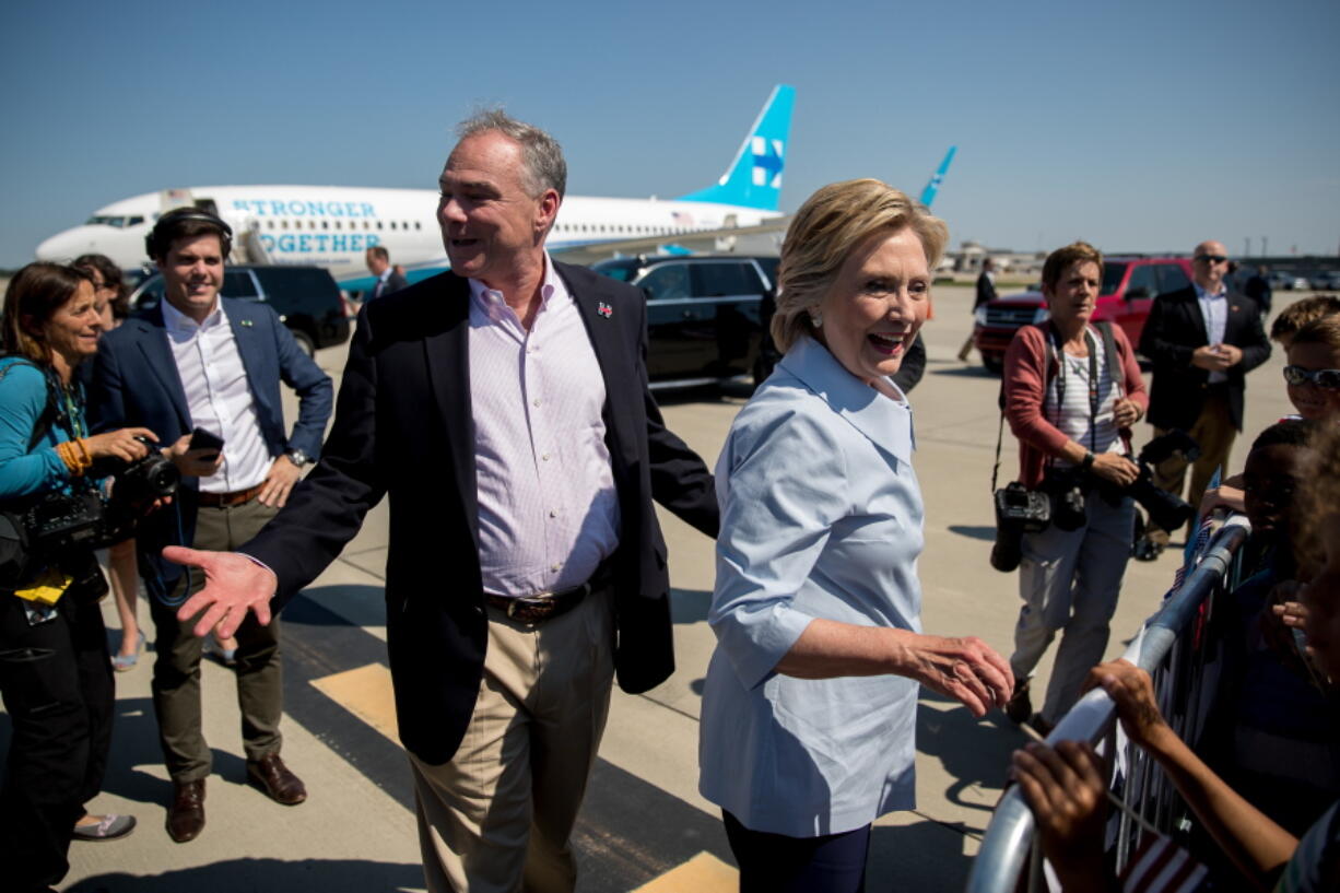 Democratic presidential candidate Hillary Clinton, center right, and Democratic vice presidential candidate, Sen. Tim Kaine, D-Va., center left, greet members of a crowd as Clinton arrives at Cleveland Hopkins International Airport in Cleveland, Ohio, Monday after traveling from Westchester County Airport in White Plains, N.Y.