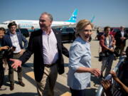 Democratic presidential candidate Hillary Clinton, center right, and Democratic vice presidential candidate, Sen. Tim Kaine, D-Va., center left, greet members of a crowd as Clinton arrives at Cleveland Hopkins International Airport in Cleveland, Ohio, Monday after traveling from Westchester County Airport in White Plains, N.Y.