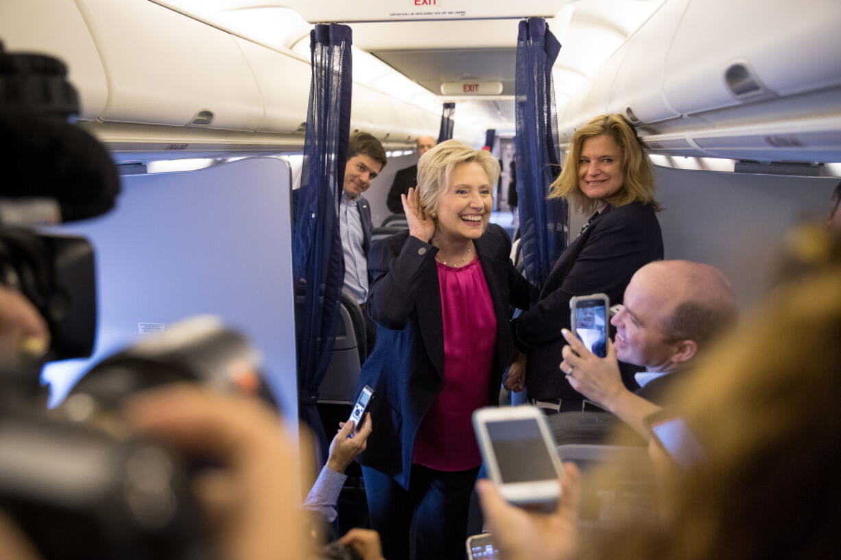 Democratic presidential candidate Hillary Clinton, accompanied by traveling press secretary Nick Merrill, left, and director of communications Jennifer Palmieri, right, listens to a question from a member of the media as her campaign plane prepares to take off at Westchester County Airport in Westchester, N.Y., on Tuesday to head to Tampa for a rally in Tampa.