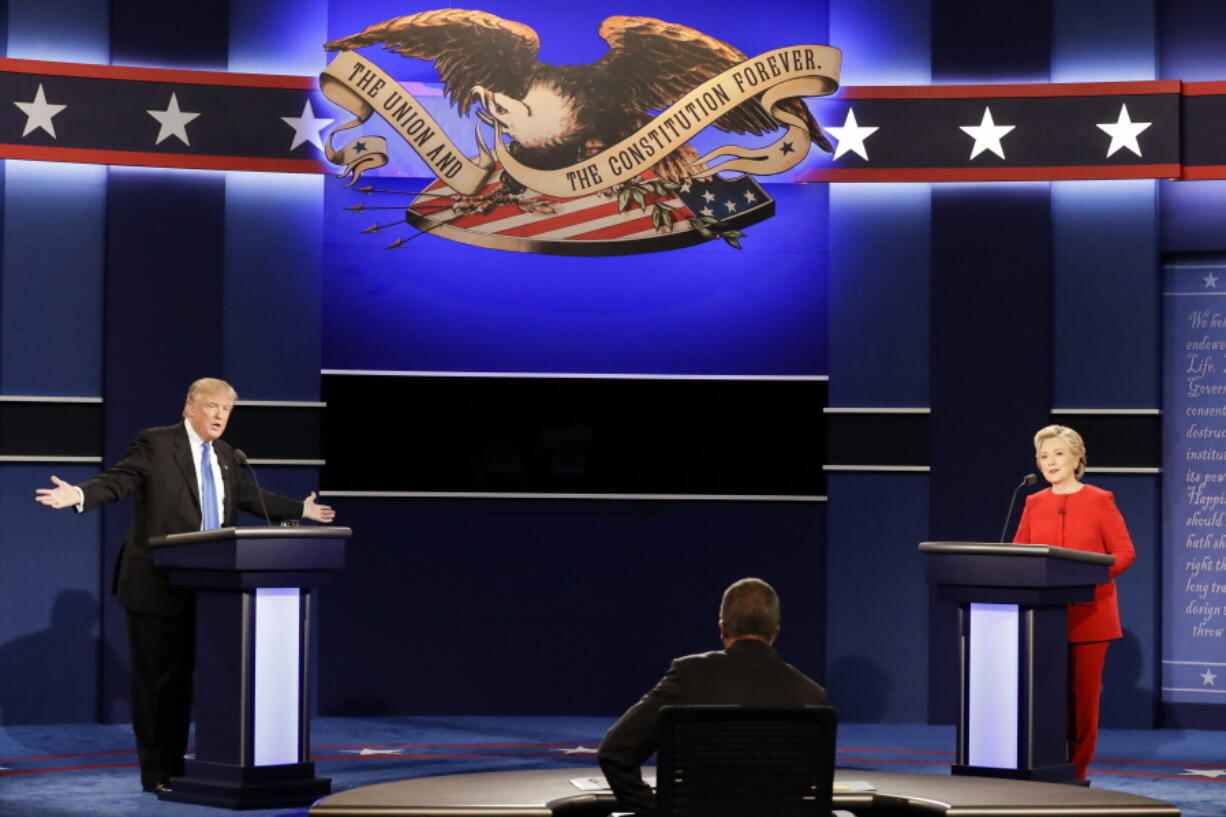 Republican presidential nominee Donald Trump answers a question as Democratic presidential nominee Hillary Clinton listens during the presidential debate at Hofstra University in Hempstead, N.Y., on Monday.