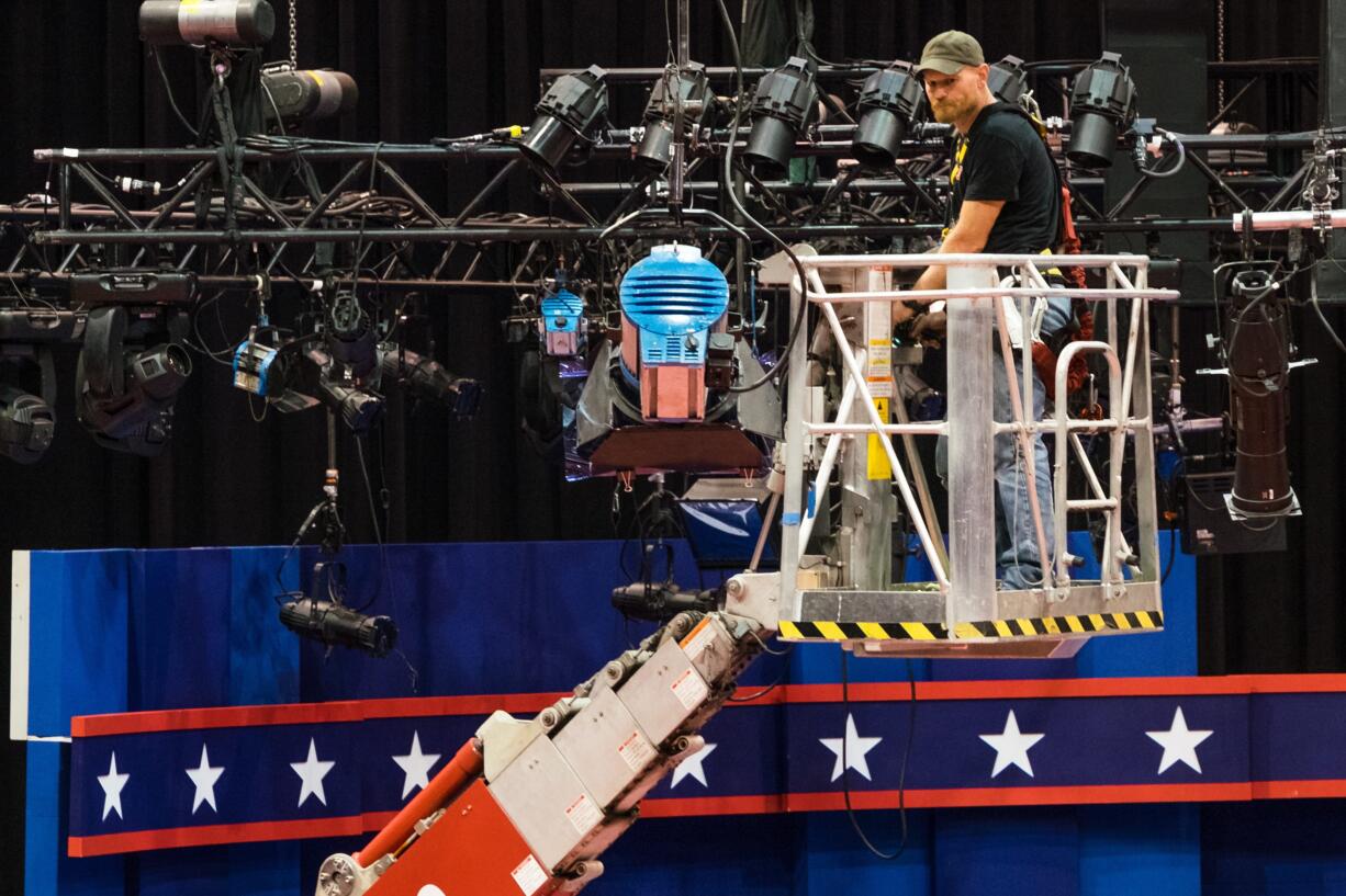 A technician examines the lighting grid as preparations continue for Monday's first debate presidential between Democratic Hillary Clinton and Republican Donald Trump, Saturday, Sept. 24, 2016, at Hofstra University in Hempstead, N.Y.  (AP Photo/J.