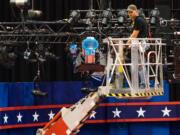 A technician examines the lighting grid as preparations continue for Monday's first debate presidential between Democratic Hillary Clinton and Republican Donald Trump, Saturday, Sept. 24, 2016, at Hofstra University in Hempstead, N.Y.  (AP Photo/J.