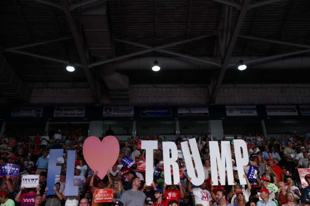 Supporters hold signs for Republican presidential candidate Donald Trump during a campaign rally Monday at Germain Arena in Ft. Myers, Fla.