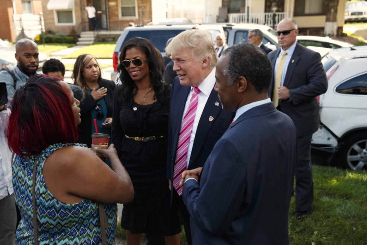 Neighborhood resident Felicia Reese, left, talks with Republican presidential candidate Donald Trump and Dr. Ben Carson, during a tour of Carson&#039;s childhood home, Saturday, Sept. 3, 2016, in Detroit.