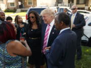 Neighborhood resident Felicia Reese, left, talks with Republican presidential candidate Donald Trump and Dr. Ben Carson, during a tour of Carson&#039;s childhood home, Saturday, Sept. 3, 2016, in Detroit.