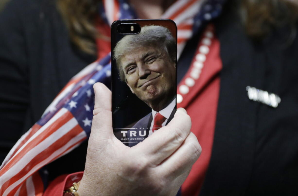 A woman holds up her cellphone Thursday before a rally with Republican presidential candidate Donald Trump in Bedford, N.H.