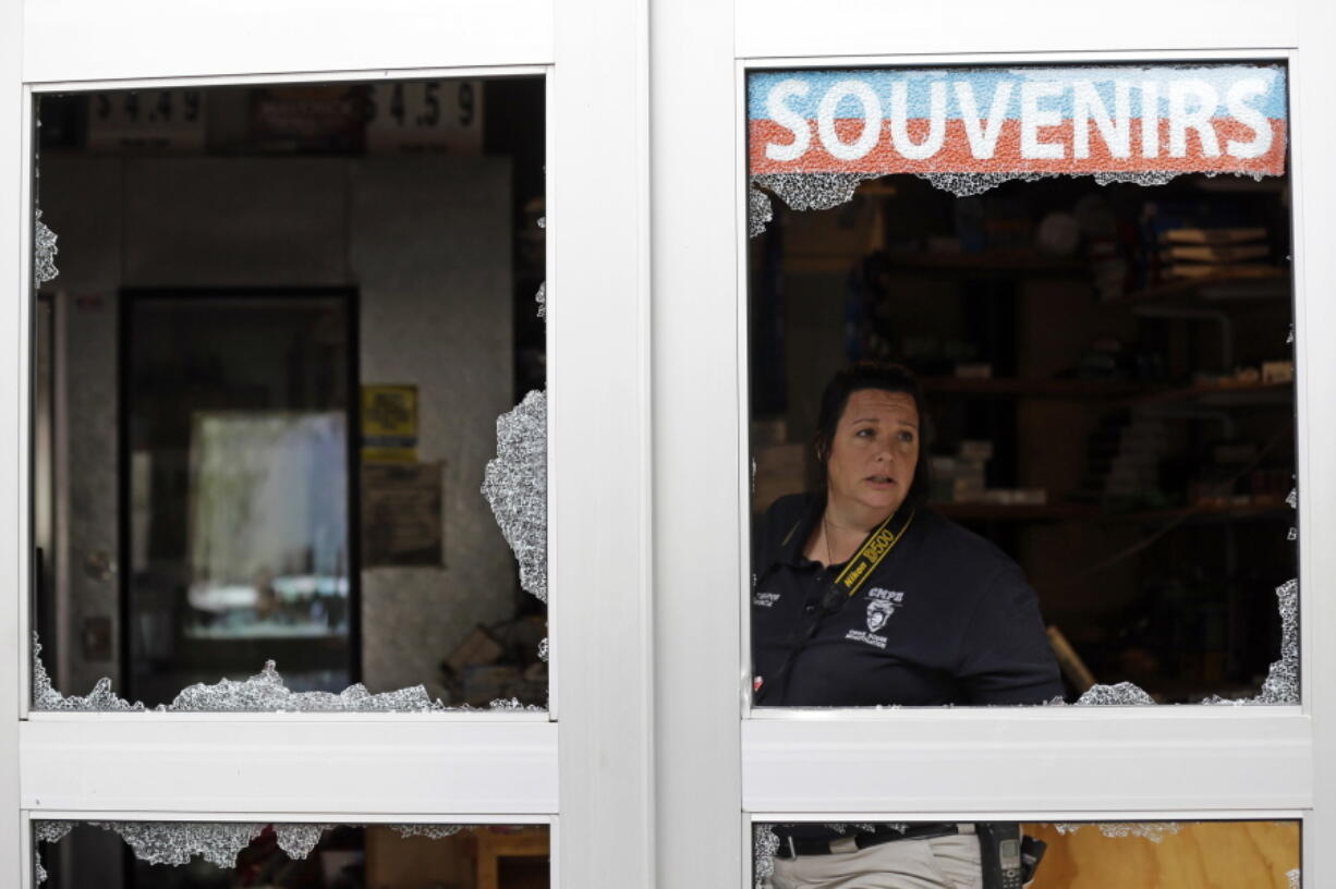 A crime scene photographer looks out a storefront damaged overnight by protesters following Tuesday&#039;s police shooting of Keith Lamont Scott in Charlotte, N.C., Thursday. Charlotte&#039;s police chief said Thursday he plans to show video of an officer shooting Scott to his family, but the video won&#039;t be immediately released to the public.