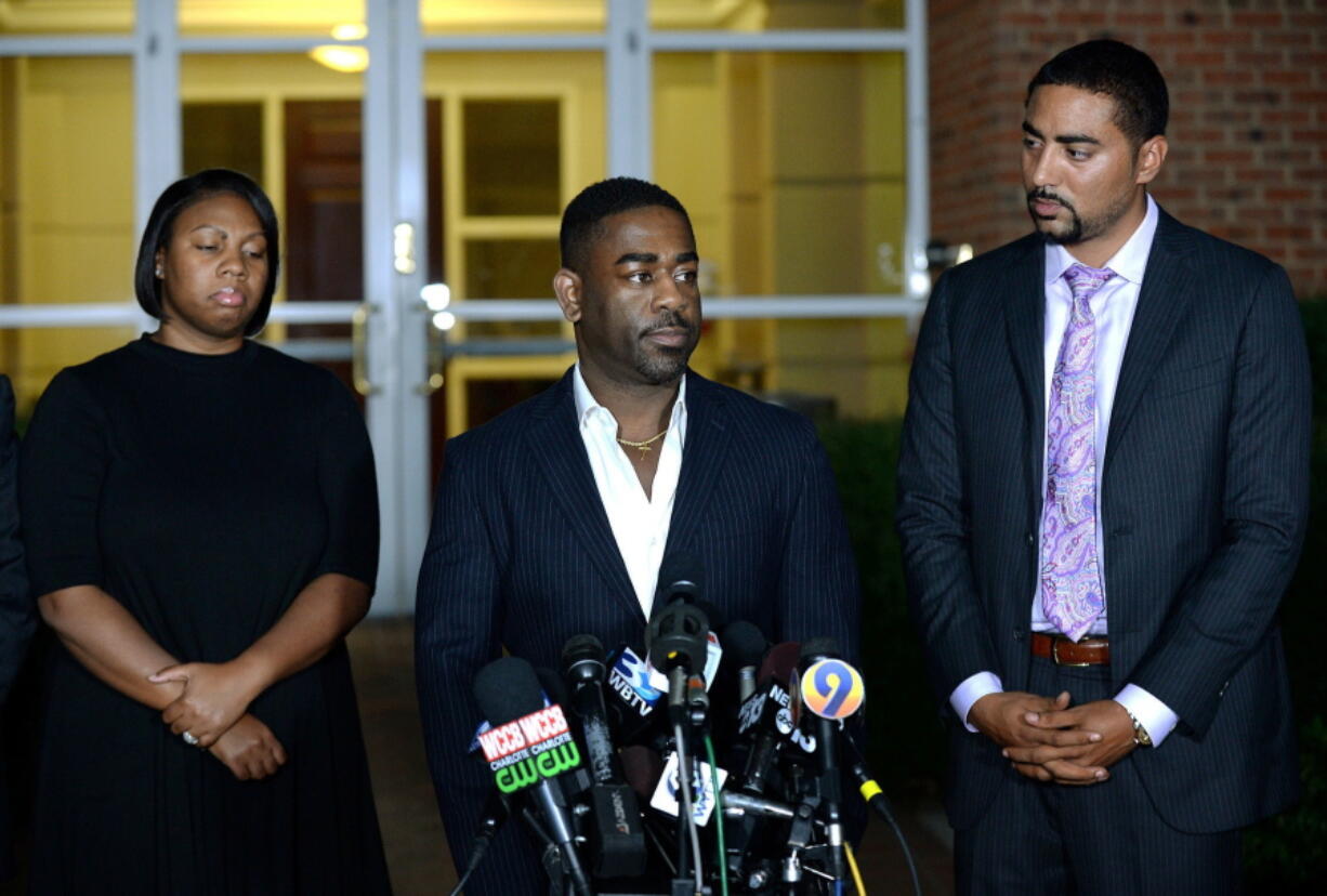 Rachel, left, and Ray Dotch, center, sister-in-law and brother-in-law to Keith Lamont Scott, give a news conference in Charlotte, N.C., on Saturday. At right is the family&#039;s attorney, Justin Bamberg. Scott was fatally shot by Charlotte-Mecklenburg Police Officer Brentley Vinson on Tuesday.