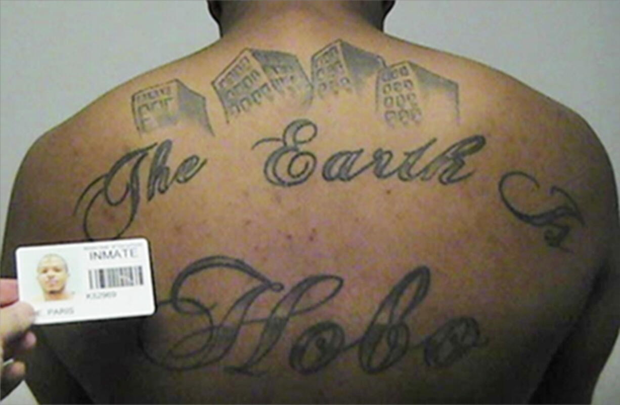 This undated photo in a court filing provided by the United States Attorney&#039;s office in Chicago, shows Paris Poe&#039;s back tattoo that reads &#039;The Earth Is Our Turf, and Hobo. Poe is one of six defendants on trial for racketeering and other charges are purported leaders of the widely feared Hobos, a South Side gang that federal prosecutors say murdered, maimed and tortured their way into control of some of Chicago&#039;s most lucrative drug markets. Their federal trial begins Wednesday with opening statements in Chicago.