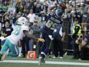 Seattle Seahawks wide receiver Doug Baldwin (89) catches a pass for a touchdown over Miami Dolphins cornerback Bobby McCain (28) in the second half of an NFL football game, Sunday, Sept. 11, 2016, in Seattle.