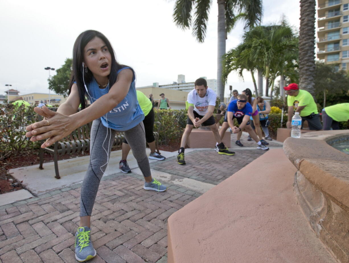 &quot;Sweatworking&quot; runners stretch near the Running Wild running store before heading out to the Westin Fort Lauderdale Beach Resort during their weekly run in Fort Lauderdale, Fla.