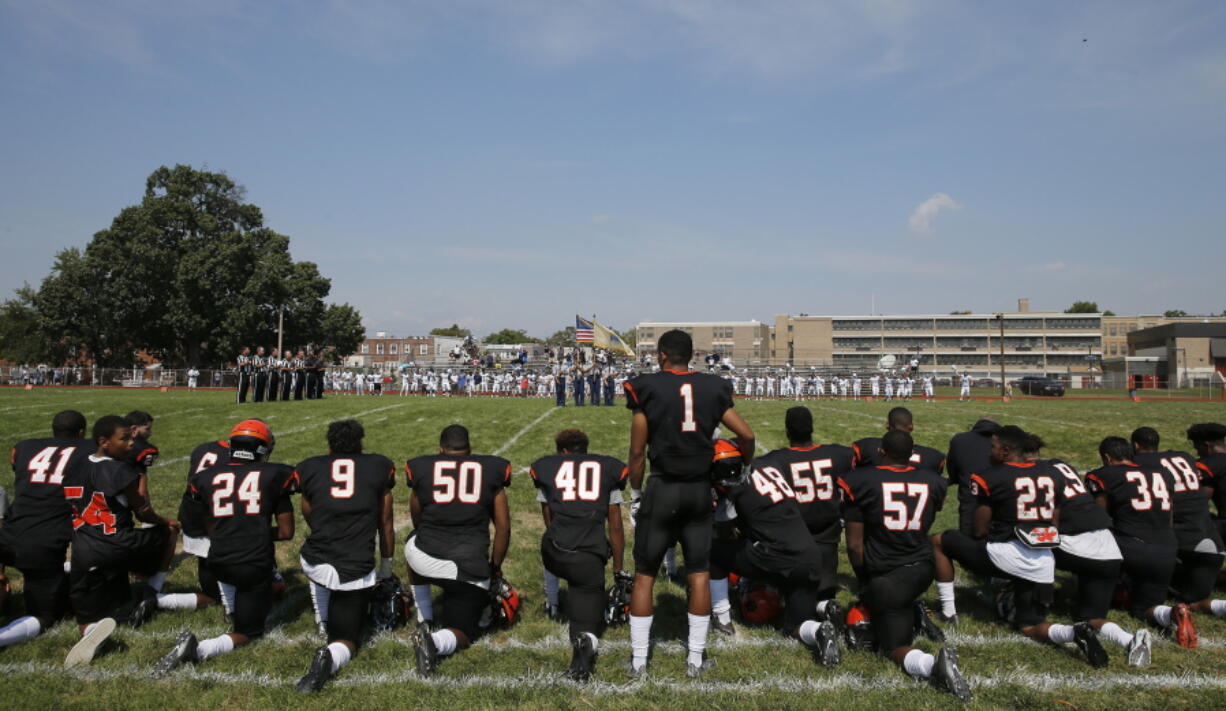 Woodrow Wilson High&#039;s Edwin Lopez (1) stands while some of his teammates kneel during the national anthem before Wilson played Highland Camden, N.J., on Saturday.