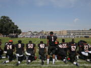 Woodrow Wilson High&#039;s Edwin Lopez (1) stands while some of his teammates kneel during the national anthem before Wilson played Highland Camden, N.J., on Saturday.