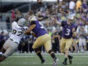 Washington quarterback Jake Browning (3) passes as Idaho defensive end Aikeem Coleman, left, is blocked by Washington offensive lineman Nick Harris, center, in the first half of an NCAA college football game, Saturday, Sept. 10, 2016, in Seattle. (AP Photo/Ted S.