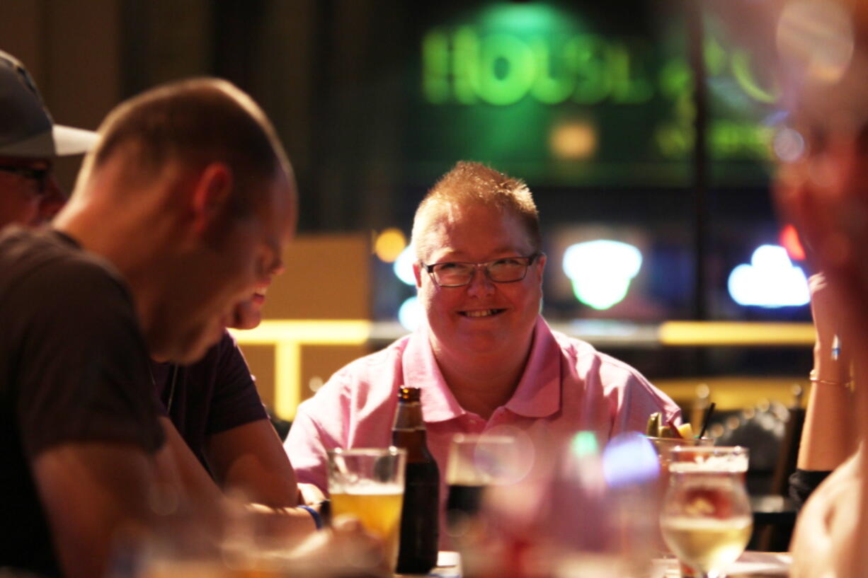 Angela Caddell smiles during a Sept. 13 &quot;Jesus &amp; Beer&quot; event at a Waukesha, Wis., pub, organized by CollectiveMKE church, which doesn';t have a traditional building. The group holds these discussions monthly at Milwaukee and Waukesha bars. It's part of a national effort by religious groups looking for ways to recruit new parishioners, connect with people struggling with their faith or give a different, relaxed outlet to talk religion.