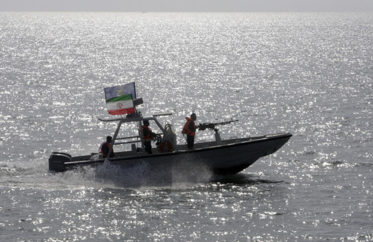 An Iranian Revolutionary Guard speedboat escorts a passenger ship, unseen, near the spot where an Iranian airliner was shot down by a U.S. warship 24 years ago killing 290 passengers.