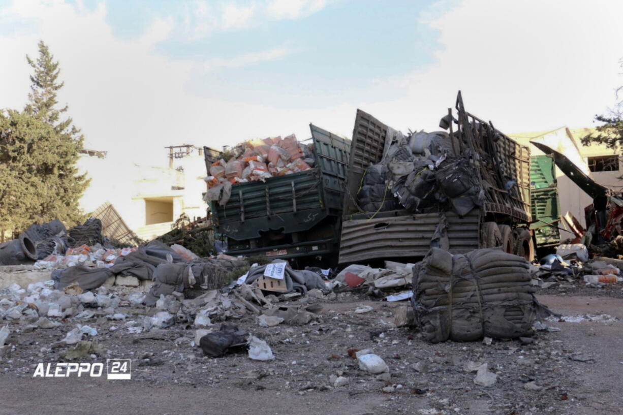 This image provided by the Syrian anti-government group Aleppo 24 news shows damaged trucks carrying aid, in Aleppo, Syria, on Tuesday. A U.N. humanitarian aid convoy in Syria was hit by airstrikes Monday as the Syrian military declared that a U.S.-Russian brokered cease-fire had failed, and U.N. officials reported many dead and seriously wounded.