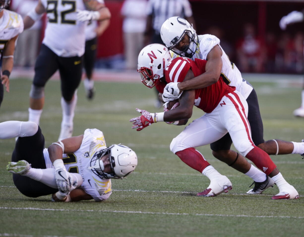 Oregon wide receiver Devon Allen, left, grabs his knee after trying to tackle a kickoff return by Nebraska wide receiver De&#039;Mornay Pierson-El (15).