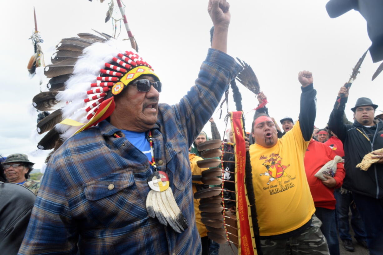 JR American Horse raises his fist with others while leading a march from a protest camp to the Dakota Access Pipeline site Friday in southern Morton County, N.D.