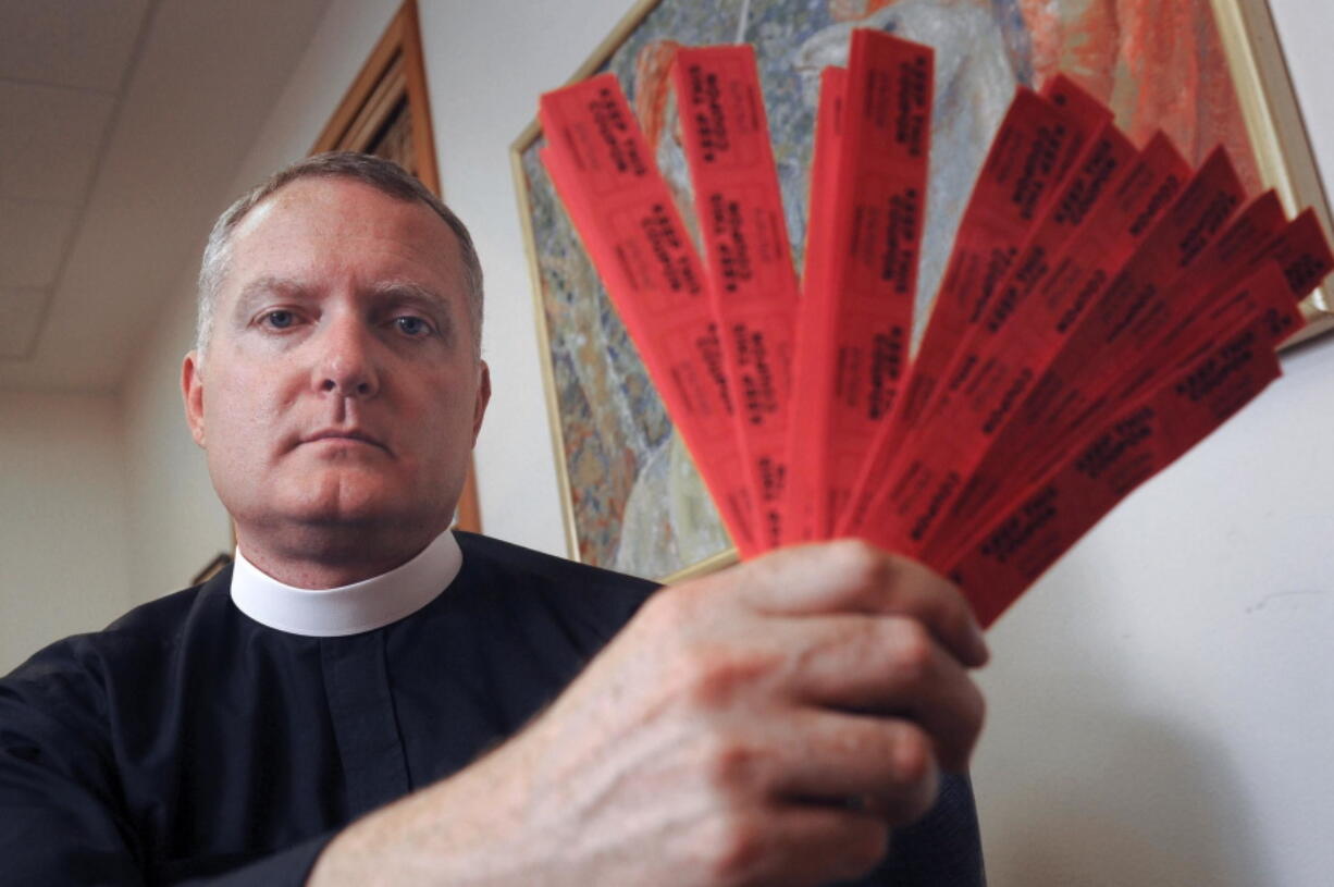 FILE--In this July 27, 2016, file photo, Rev. Jeremy Lucas of Christ Church Episcopal Parish holds the 150 tickets that he purchased in an all-star softball team&#039;s raffle to win an AR-15 assault rifle in Lake Oswego, Ore. Authorities have decided Lucas won&#039;t be charged for giving the assault rifle to a gun-owning friend for safekeeping without a background check, Thursday, Sept. 15, 2016.