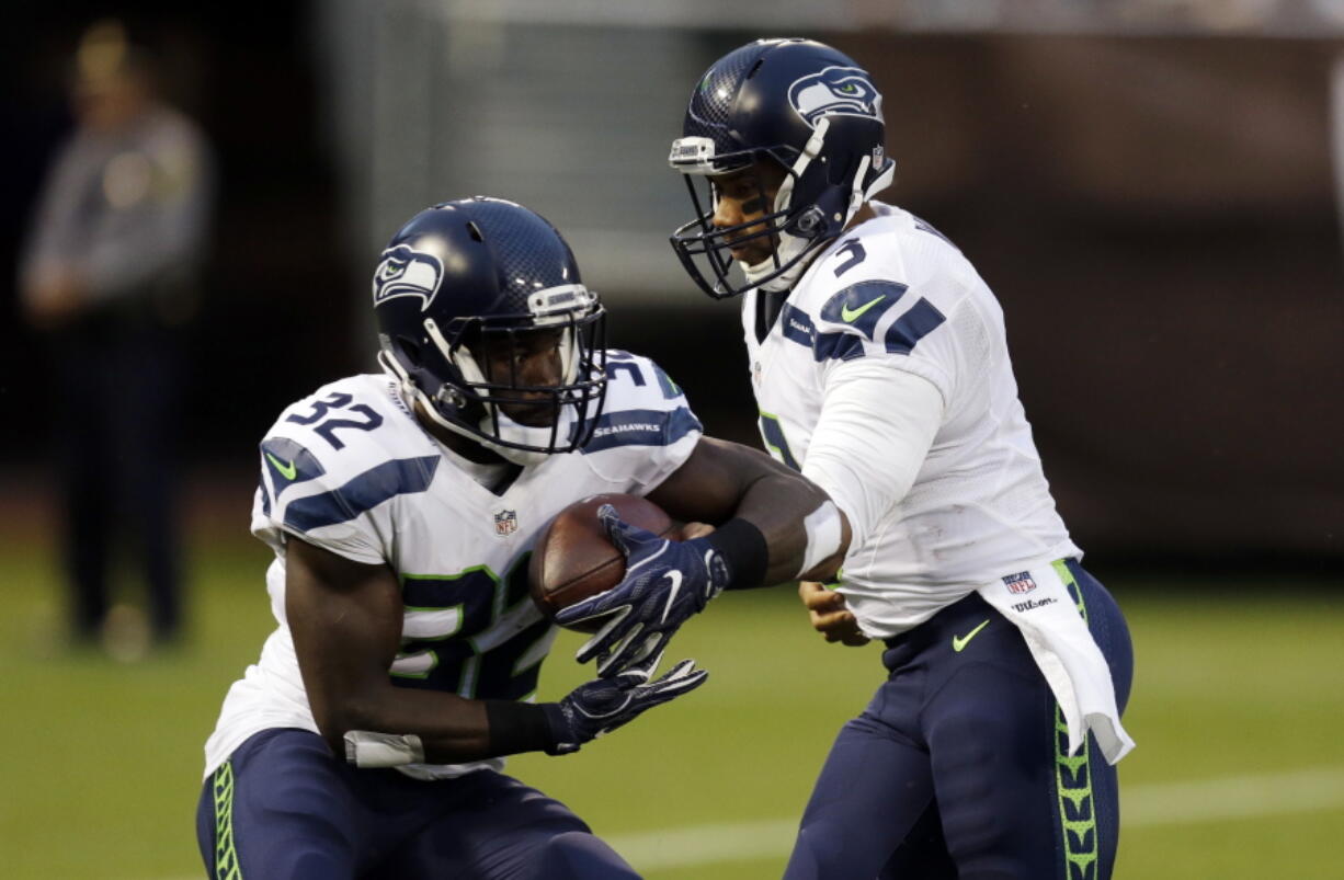 Seattle Seahawks quarterback Russell Wilson (3) hands off to running back Christine Michael during the first half of a preseason NFL football game against the Oakland Raiders, Thursday, Sept. 1, 2016, in Oakland, Calif.