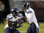 Seattle Seahawks quarterback Russell Wilson (3) hands off to running back Christine Michael during the first half of a preseason NFL football game against the Oakland Raiders, Thursday, Sept. 1, 2016, in Oakland, Calif.