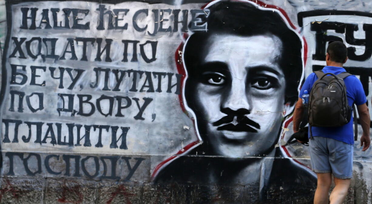 A man walks past graffiti on a wall showing Gavrilo Princip, the Bosnian-Serb nationalist who assassinated Archduke Franz Ferdinand in 1914, in Belgrade, Serbia, on Tuesday.