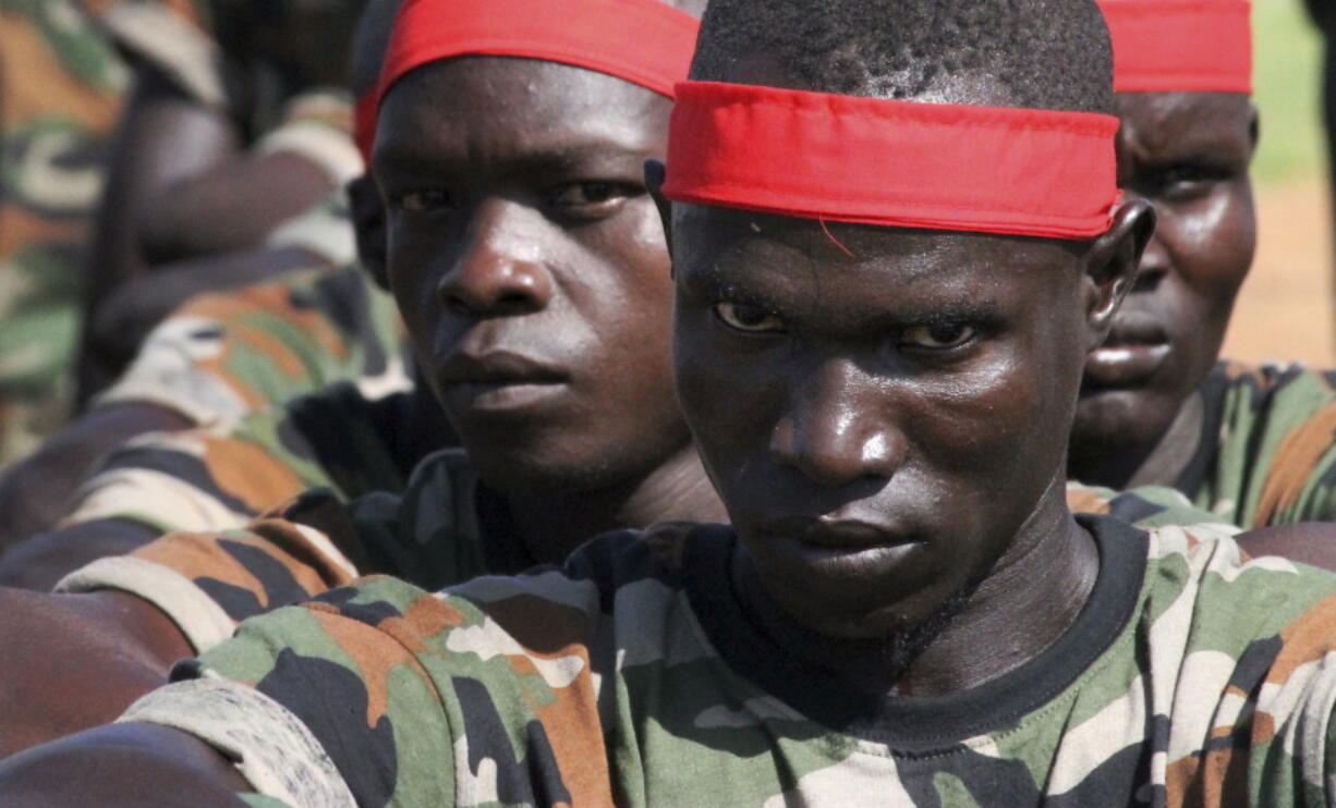 A group of government soldiers wait in line May 16 during a military parade celebrating the national army in Juba, South Sudan. A new report Monday by a U.S.-based watchdog group accuses South Sudan&#039;s rival leaders of amassing wealth abroad amid a conflict in which tens of thousands have been killed.