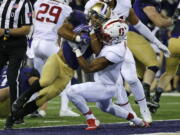 Washington running back Myles Gaskin, left, powers past Stanford safety Justin Reid, right, for a touchdown. Gaskin rushed for 100 yards in the win over Stanford. (Ted S.