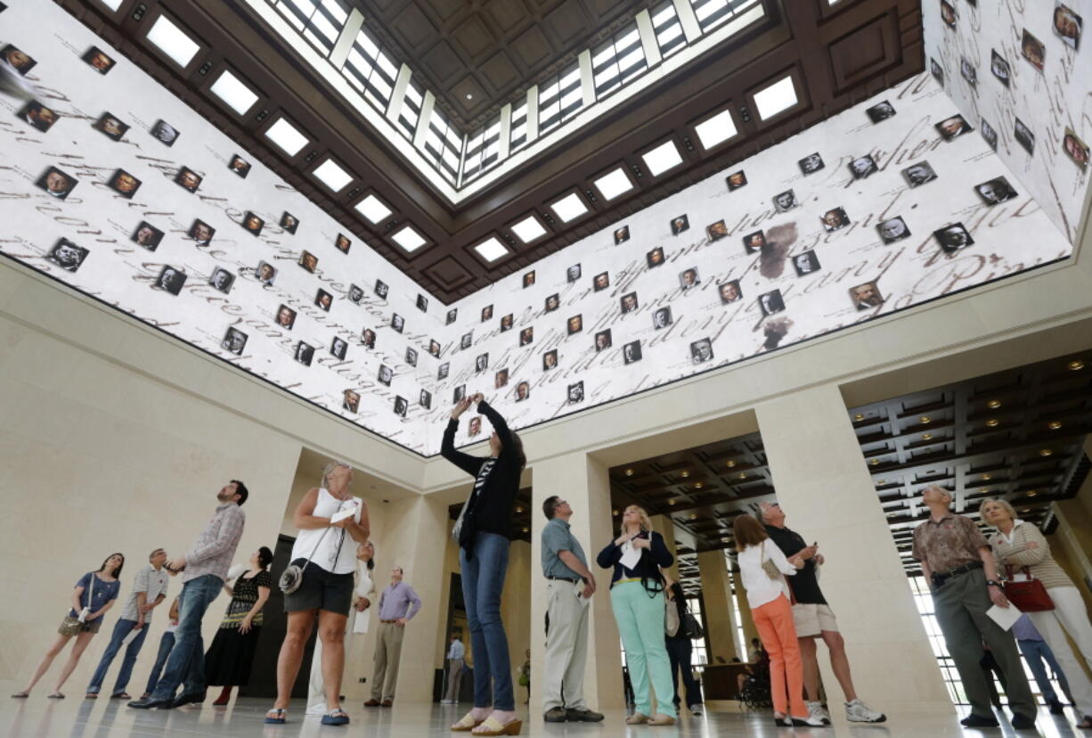 Visitors to the George W. Bush Presidential Library and Museum look upwards at a 360 degree video screen showing a video welcoming them to the center in Dallas on May 1, 2013.