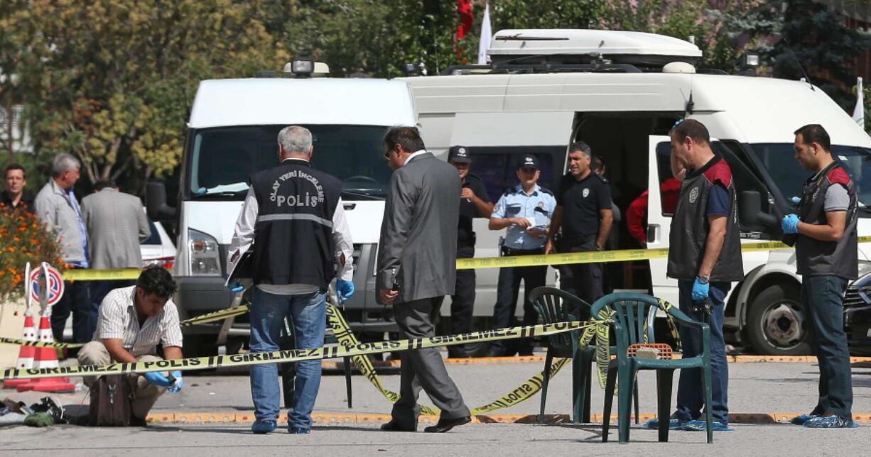 Police officers examine the scene Wednesday outside the Israeli Embassy in Ankara, Turkey, where a solo attacker was shot and wounded.