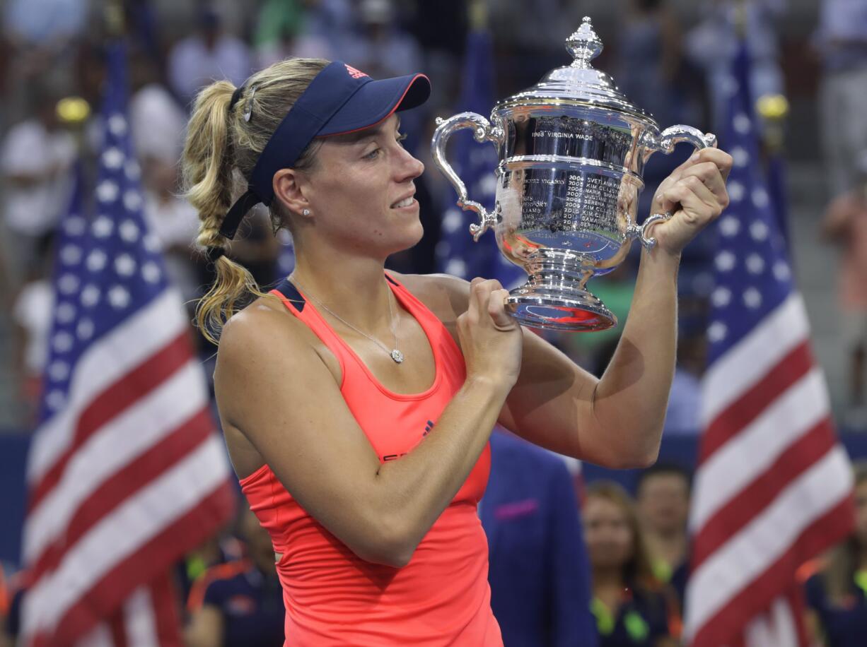 Angelique Kerber, of Germany, holds up the championship trophy after beating Karolina Pliskova, of the Czech Republic, to win the women's singles final of the U.S. Open tennis tournament, Saturday, Sept. 10, 2016, in New York.