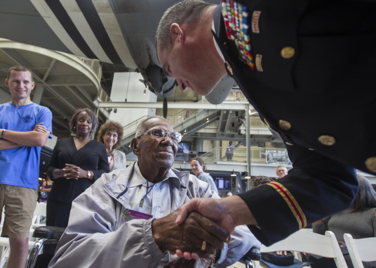 World War II veteran Lawrence Brooks, 107, left, gets a birthday handshake from Lt. Col. Austin Appleton with the U.S. Army Corps of Engineers during a birthday celebration for Brooks on Monday at The National World War II Museum in New Orleans.