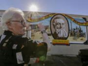 Canadian tourist Wayne Webb stops to take a photo of the mural &quot;Waterman Junction Becomes Barstow, 1886,&quot; on a building along Main Street in Barstow, Calif.