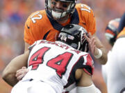 Denver Broncos quarterback Paxton Lynch (12) is sacked by Atlanta Falcons outside linebacker Vic Beasley (44) during the second half of an NFL football game, Sunday, Oct. 9, 2016, in Denver.