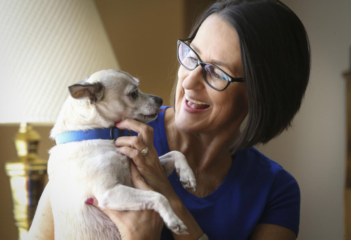 Michele Longabaugh holds her Chihuahua, Smokey. Longabaugh acquired Smokey from the Kansas Humane Society just an hour or so after she learned she had cancer. She is currently cancer-free and says Smokey helped make the chemo, radiation and surgery bearable. &quot;Through long nights of misery and pain, he was there for me,&quot; she said.